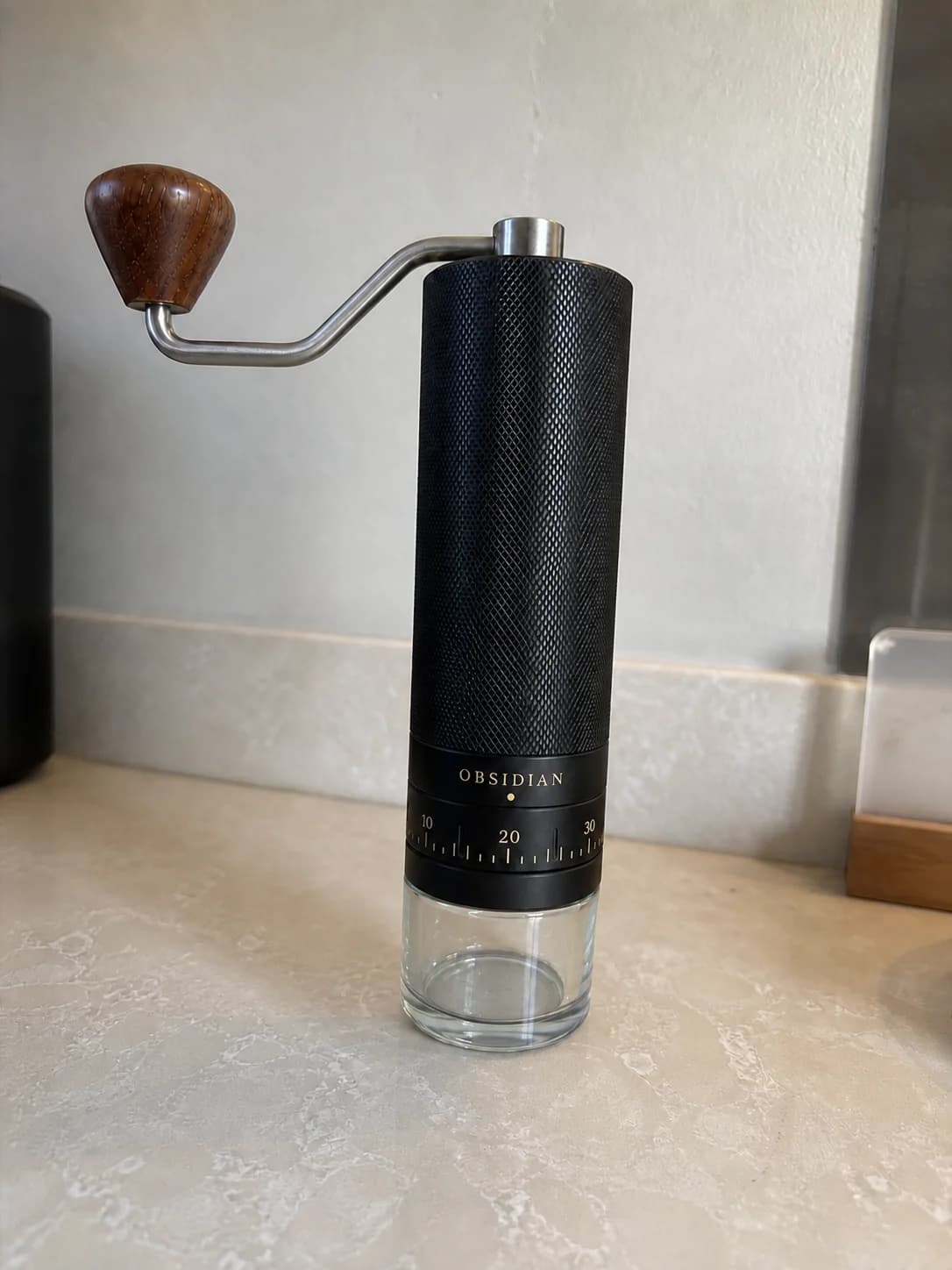 Simulated amateur phone photograph of the fictional Obsidian grinder on a kitchen counter